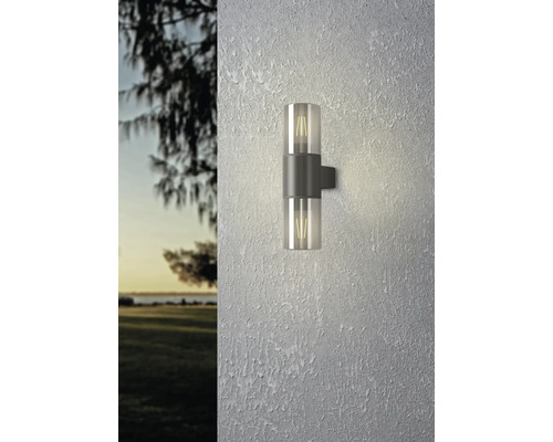 Anthrazitfarbene Außenwandleuchte in Zylinderform mit Up-and-Down-Lichteffekt, montiert an einer hellen, strukturierten Fassade.
