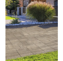 Moderne Pflastersteine in einem hellen Garten mit Ziergras und weißem Zierkies.