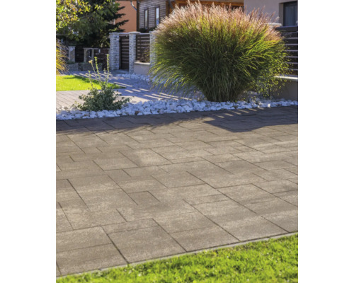 Moderne Pflastersteine in einem hellen Garten mit Ziergras und weißem Zierkies.