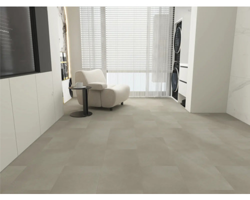 Großformatige Bodenfliesen in hellem Grau, moderner Wohnbereich mit weißem Sessel, Beistelltisch und Fensterfront, heller und geräumiger Raum.