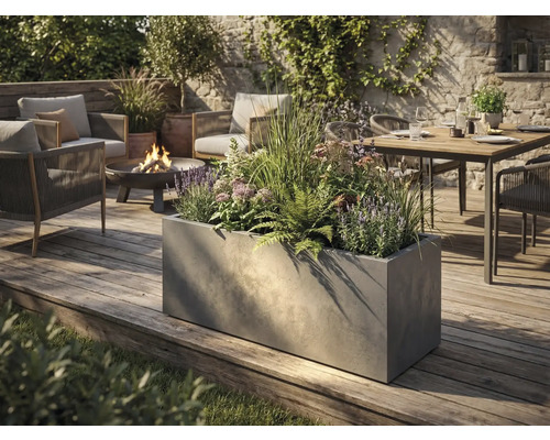 Großer rechteckiger Pflanzkübel in Betonoptik auf einer Holzterrasse in einem modern gestalteten Garten mit Sitzgruppe und Feuerschale.