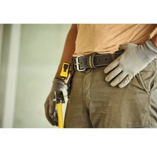 Lederner Arbeitsgürtel mit Stanley Logo an einer Person in Arbeitskleidung mit Arbeitshandschuhen und Werkzeug.