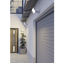 Zwei flache LED-Außenstrahler an einer weißen Hauswand beleuchten den Garagen- und Eingangsbereich eines modernen Wohnhauses.