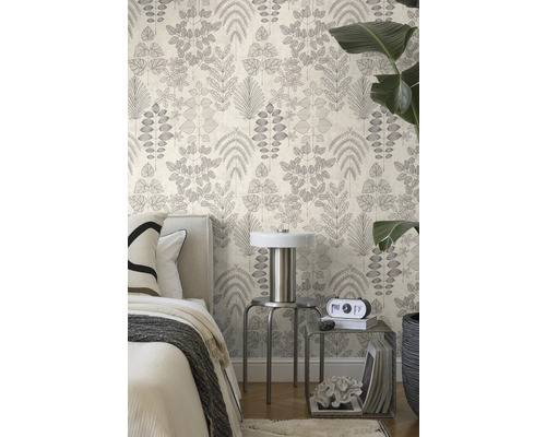 Vliestapete mit botanischem Blattmuster in einem hellen Schlafzimmer mit Bett, Metalltischen und einer großen Zimmerpflanze.