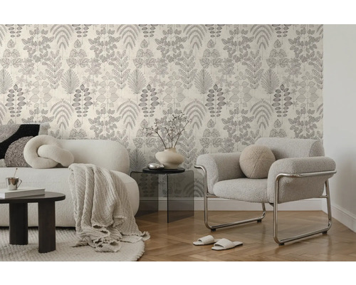 Tapete mit botanischem Blattmuster in einem modern eingerichteten Wohnzimmer mit Sofa, Sessel und Parkettboden.