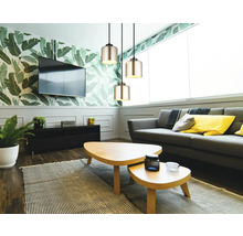 Modernes Wohnzimmer mit drei zylindrischen Glas-Pendelleuchten, grauem Sofa, Holz-Couchtischen und botanischer Tapete.