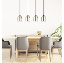 Vierflammige Pendelleuchte mit geriffelten Glasschirmen über Holztisch mit grauen Polsterstühlen in hellem, modernem Esszimmer.