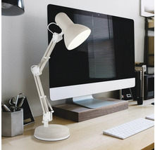 Verstellbare Schreibtischlampe mit Gelenkarm neben einem Computer auf einem hellen Schreibtisch in einem organisierten Arbeitszimmer.