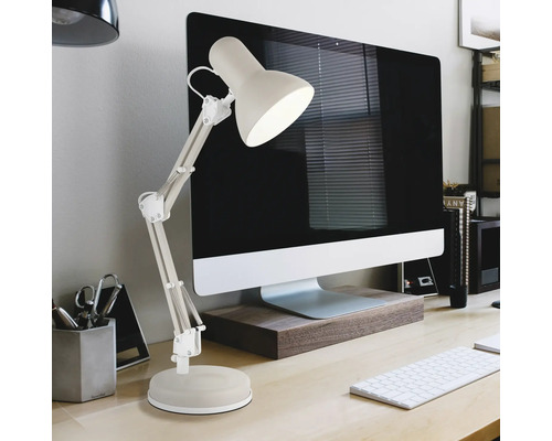Verstellbare Schreibtischlampe mit Gelenkarm neben einem Computer auf einem hellen Schreibtisch in einem organisierten Arbeitszimmer.