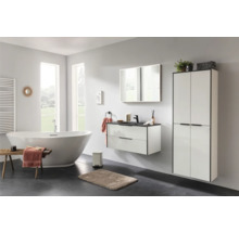 Modernes Badezimmer mit freistehender Badewanne, wandhängendem Waschtischunterschrank und hohem Badschrank in Weiß mit schwarzen Akzenten.