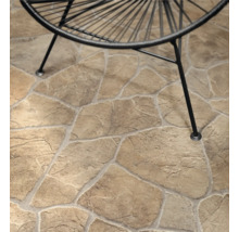 Polygonalplatten in Natursteinoptik auf einer Terrasse mit den Beinen eines Gartenstuhls.