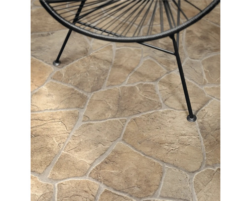 Polygonalplatten in Natursteinoptik auf einer Terrasse mit den Beinen eines Gartenstuhls.