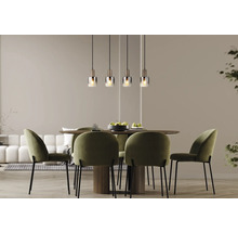 Modernes Esszimmer mit vier Glas-Pendelleuchten über einem runden Holztisch und vier grünen Samtstühlen.