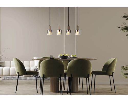 Modernes Esszimmer mit vier Glas-Pendelleuchten über einem runden Holztisch und vier grünen Samtstühlen.