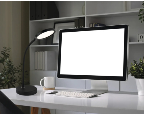 Moderne LED-Schreibtischleuchte auf einem organisierten Schreibtisch mit Monitor, Tastatur und weißem Becher in einem hellen Arbeitszimmer.
