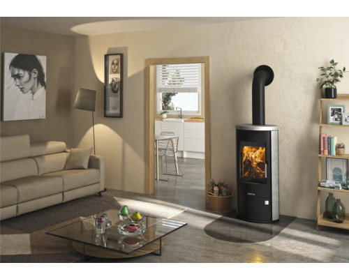 Moderner schwarzer Kaminofen mit Steinverkleidung und brennendem Feuer in einem hellen Wohnzimmer mit Glasbodenplatte.