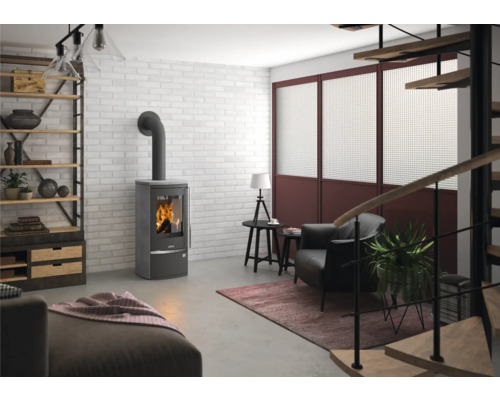Moderner Kaminofen in Grau in einem Wohnzimmer im industriellen Stil mit weißer Ziegelwand, Sessel und Holzregal.