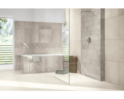 Modernes helles Badezimmer mit Einbaubadewanne und begehbarer Dusche mit Glastrennwand. Graue Wandfliesen in verschiedenen Formaten und Mosaikbordüre.