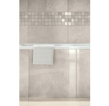 Badezimmer mit hellen Wandfliesen in Steinoptik, einer Mosaikbordüre und einer Badewanne mit glänzender Marmoroptik-Verkleidung.