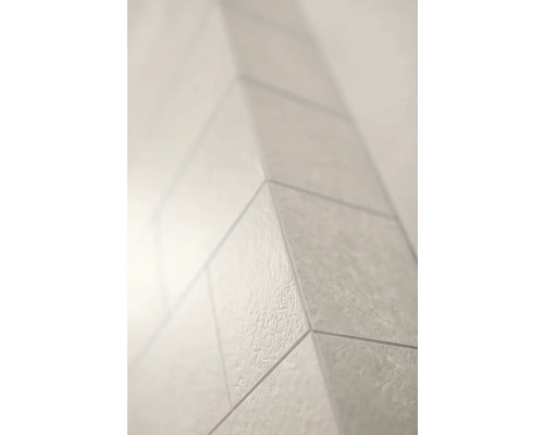 Nahaufnahme einer Außenecke mit strukturierten hellen Fliesen für Wand oder Boden.