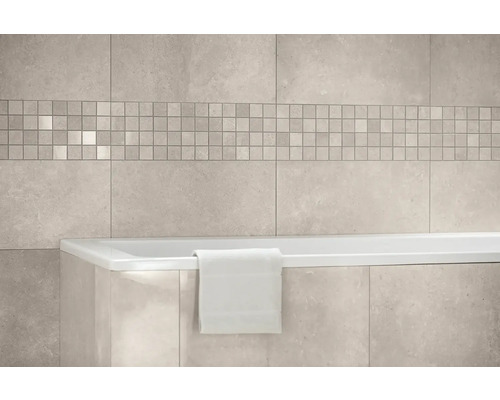 Modernes Badezimmer mit großformatigen Wandfliesen in Steinoptik, einer Mosaikbordüre und einer weißen Badewanne.