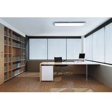 Modernes, helles Büro mit L-förmigem Schreibtisch, schwarzem Bürostuhl, großem Holzregal und deckenhohen Fenstern mit Jalousien.