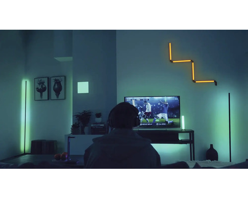 Modernes Wohnzimmer mit verschiedenen LED-Stehlampen und einer LED-Wandleuchte für indirekte Smart Home Beleuchtung beim Fernsehen.