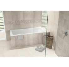 Modernes Badezimmer mit eingebauter Badewanne, hellen Wandfliesen in Natursteinoptik, Mosaikbordüre, Glaswand und geflochtenem Wäschekorb.
