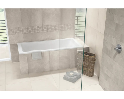 Modernes Badezimmer mit eingebauter Badewanne, hellen Wandfliesen in Natursteinoptik, Mosaikbordüre, Glaswand und geflochtenem Wäschekorb.