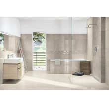 Modernes Badezimmer mit beigen Wandfliesen und Bodenfliesen, Mosaikbordüre, Badewanne, begehbarer Dusche mit Glaswand und Waschtischunterschrank.
