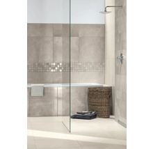 Modernes Badezimmer mit großformatigen Wandfliesen in Steinoptik, einer Mosaikbordüre, Badewanne, Glasduschwand und Regendusche.