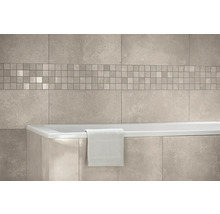 Wandfliesen in Steinoptik mit einer Mosaikbordüre über einer Badewanne mit einem Handtuch in einem hellen Badezimmer.