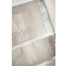 Modernes Badezimmer mit Wandfliesen in Steinoptik und einer horizontalen Mosaikbordüre über einer weißen Badewanne.