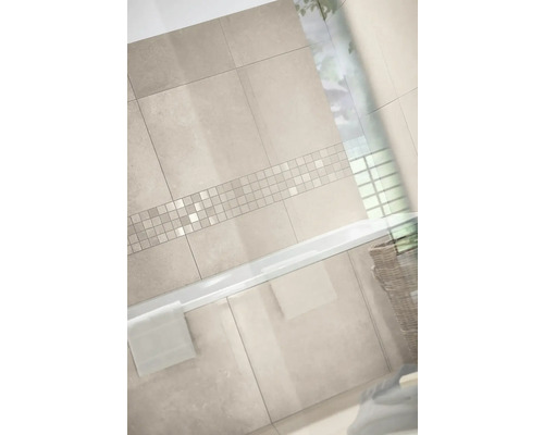 Modernes Badezimmer mit Wandfliesen in Steinoptik und einer horizontalen Mosaikbordüre über einer weißen Badewanne.