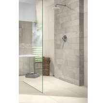 Modernes helles Badezimmer mit begehbarer Dusche, Glastrennwand, grauen Wandfliesen in Steinoptik und Regenduschkopf.
