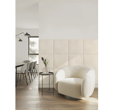 Modernes Wohnzimmer mit quadratischen gepolsterten Wandpaneelen, einem runden Sessel und einem Essbereich in einem hellen, organisierten Raum.