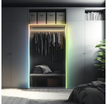 LED-Lichtstreifen an einem Kleiderschrank in einem organisierten Schlafzimmer. Mehrfarbige Beleuchtung am Schrankrahmen.