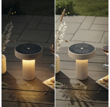 Moderne Solar-Tischleuchte mit geriffeltem Sockel auf einem Gartentisch, Vergleichsansicht bei Tageslicht und in der Dämmerung mit warmem Licht.