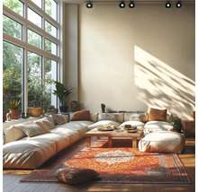 Helles Wohnzimmer mit großem modularem Sofa, Holztisch und Orientteppich vor einer großen Fensterfront mit Deckenstrahlern.