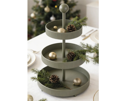 Dreistöckige Etagere aus Metall dekoriert mit Tannenzweigen, Zapfen und Weihnachtskugeln auf einem festlich gedeckten Tisch.