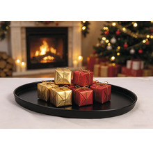 Kleine goldene und rote Geschenkboxen mit goldenen Bändern auf einem schwarzen Tablett vor einem beleuchteten Kamin und Weihnachtsbaum.
