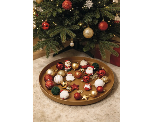 Rundes Tablett mit verschiedenen Weihnachtsornamenten wie Kugeln, Weihnachtsmannfiguren und Sternen unter einem geschmückten Weihnachtsbaum.