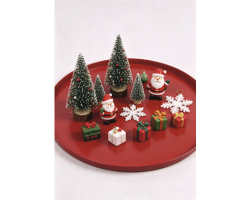 Weihnachtsdekoration-Set mit Miniatur-Tannenbäumen, Weihnachtsmann-Figuren, kleinen Geschenken und Schneeflocken auf einem roten Tablett.