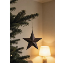 Christbaumanhänger Stern aus Metall an einem Tannenzweig hängend.