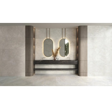 Modernes Badezimmer mit Wandfliesen in heller Steinoptik, Doppelwaschtisch in schwarzer Marmoroptik und zwei ovalen Spiegeln mit Beleuchtung.
