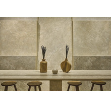 Modernes Interieur mit Wandfliesen in Natursteinoptik, passendem Steintisch, hölzernen Barhockern und dekorativen Vasen.