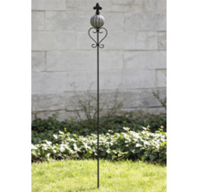 Dekorativer Gartenstab aus Metall mit Keramikkugel, Herz-Element und Lilien-Aufsatz im Garten vor einer Steinmauer.