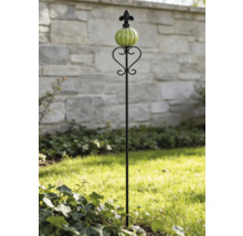 Schwarzer Beetstecker aus Metall mit grüner Glaskugel und Lilienverzierung auf einer Rasenfläche.