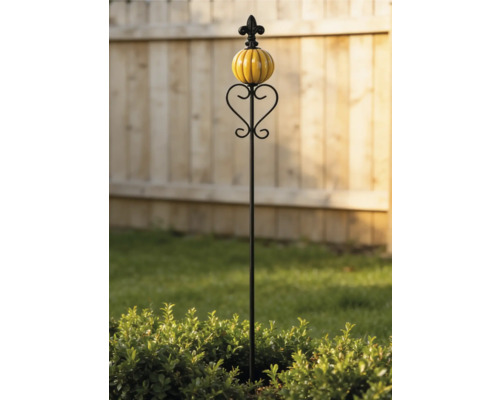 Dekorativer Gartenstecker aus Metall mit gelber Keramikkugel und herzförmiger Verzierung vor einem Holzzaun im Garten.