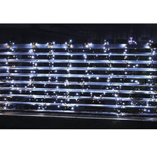 LED-Lichterkette mit kaltweißen und warmweißen Lichtern an einem Balkongeländer bei Nacht.